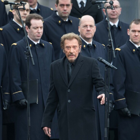 Johnny Hallyday, accompagné par Yodelice et Yarol Poupaud, chante "Un dimanche de janvier" en hommage aux victimes des attentats de janvier et novembre. Place de la République à Paris, le 10 janvier 2016.