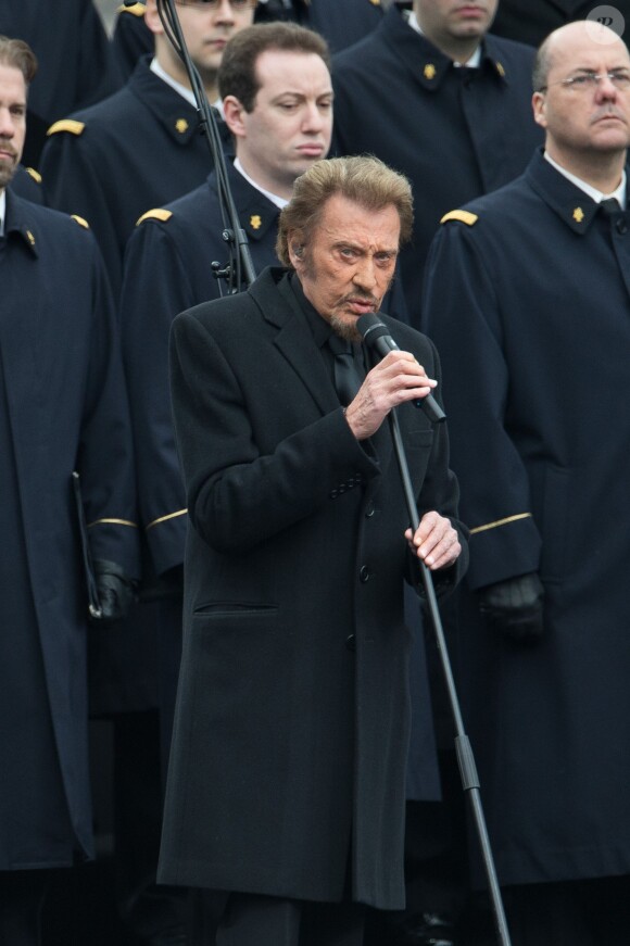 Johnny Hallyday, accompagné par Yodelice et Yarol Poupaud, chante "Un dimanche de janvier" en hommage aux victimes des attentats de janvier et novembre. Place de la République à Paris, le 10 janvier 2016.