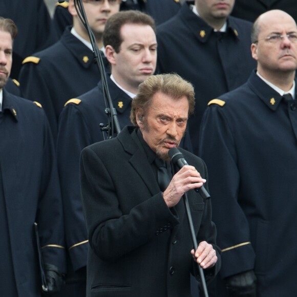 Johnny Hallyday, accompagné par Yodelice et Yarol Poupaud, chante "Un dimanche de janvier" en hommage aux victimes des attentats de janvier et novembre. Place de la République à Paris, le 10 janvier 2016.