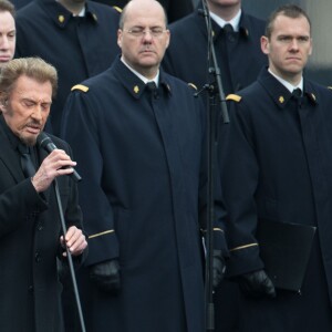 Johnny Hallyday, accompagné par Yodelice et Yarol Poupaud, chante "Un dimanche de janvier" en hommage aux victimes des attentats de janvier et novembre. Place de la République à Paris, le 10 janvier 2016.