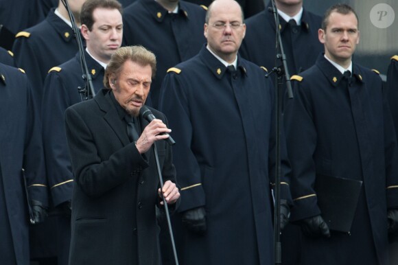 Johnny Hallyday, accompagné par Yodelice et Yarol Poupaud, chante "Un dimanche de janvier" en hommage aux victimes des attentats de janvier et novembre. Place de la République à Paris, le 10 janvier 2016.