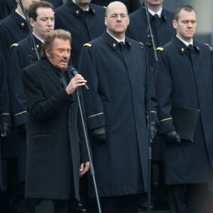 Johnny Hallyday, accompagné par Yodelice et Yarol Poupaud, chante "Un dimanche de janvier" en hommage aux victimes des attentats de janvier et novembre. Place de la République à Paris, le 10 janvier 2016.