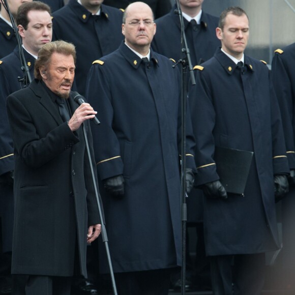 Johnny Hallyday, accompagné par Yodelice et Yarol Poupaud, chante "Un dimanche de janvier" en hommage aux victimes des attentats de janvier et novembre. Place de la République à Paris, le 10 janvier 2016.