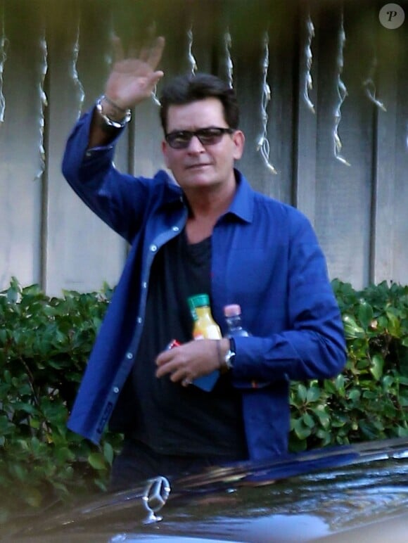 Exclusif - Charlie Sheen, qui a avoué publiquement sa séropositivité, arrive chez son père Martin pour Thanksgiving avec une amie à Malibu le 26 novembre 2015. Charlie porte une petite bouteille d'alcool et une autre de jus de fruits.