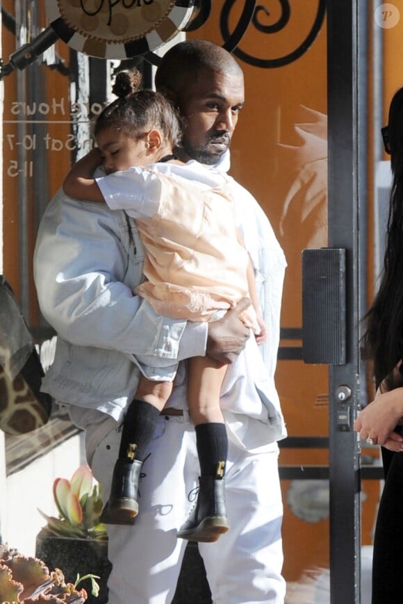 Kim Kardashian et Kanye West, qui porte sa fille North endormie, sont allés faire du shopping dans un magasin pour bébé à Los Angeles. le 21 février 2016