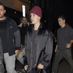 Justin Bieber, escorté par ses gardes du corps, traverse une foule de fans pour se rendre au bar "The Crow" avant d'aller faire la fête à la boîte de nuit "Tape" après la cérémonie des Brit Awards à Londres, le 24 février 2016.