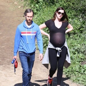 Anne Hathaway, enceinte, se promène avec son mari Adam Shulman et ses chiens à Los Angeles le 12 Mars 2016.