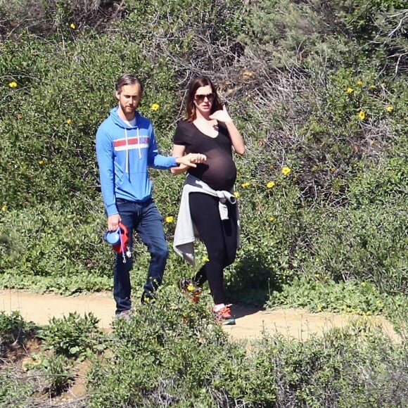 Anne Hathaway, enceinte, se promène avec son mari Adam Shulman et ses chiens à Los Angeles le 12 Mars 2016.