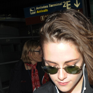 Kristen Stewart arrive à l'aéroport Roissy CDG et pose avec une fan le 25 octobre 2015