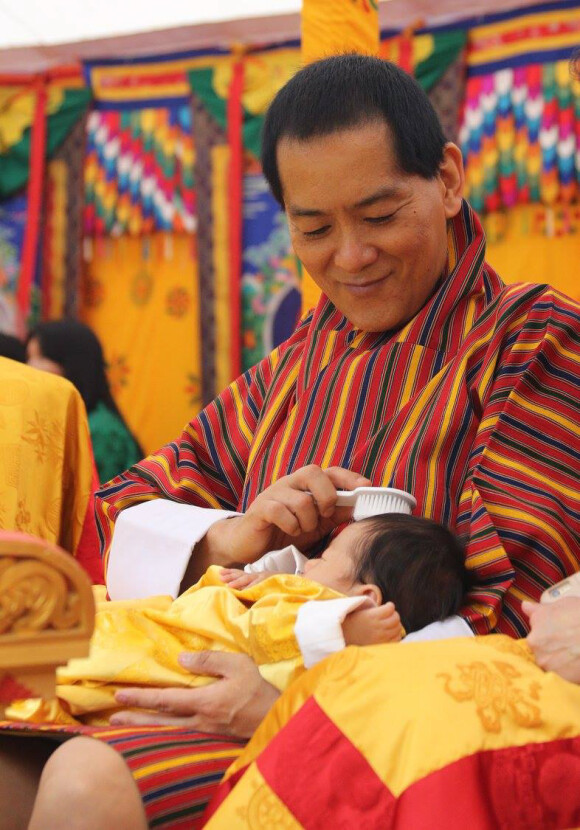 Le quatrième roi-dragon du Bhoutan, Jigme Singye Wangchuck, choyant son petit-fils le Gyalsey Jigme Namgyel Wangchuck lors de la cérémonie traditionnelle de révélation de son prénom, le 16 avril 2016 au temple de Punakha.