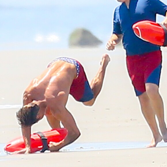 Exclusif - Zac Efron tombe lors d'une scène du film "Baywatch" alors que les acteurs doivent courir ensemble côte à côte sur la plage de Malibu pour recréer la photo mythique de la série. À Savannah, le 21 avril 2016.