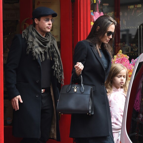 Brad Pitt, sa femme Angelina Jolie et leurs filles Vivienne et Zahara quittent un magasin de jouets à Londres le 12 mars 2016.