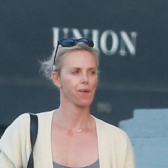 Exclusif - Charlize Theron est allée déjeuner avec ses enfants Jackson et August et s'échappe dans la rue quelques instants pour discuter et plaisanter en FaceTime avec un mystérieux inconnu à Hollywood. Elle s’amuse à faire un doigt d’honneur et envoi un baiser à son interlocuteur avant de raccrocher. Le petit Jackson porte toujours sa casquette fétiche 'reine des neiges'! Le 5 juillet 2016 For germany call for price - Please hide children face prior publication Exclusive - Actress Charlize Theron and a friend take her kids Jackson and August out for lunch in Hollywood, California on July 5, 2016. Charlize took a break from lunch to go outside and FaceTime an unknown male. She could be seen giving the phone kisses and giving the guy a middle finger. Charlize continued to support her son's choice of dressing like a Disney Princess as Jackson could be seen wearing a grey dress and a blonde wig like the character from 'Frozen'05/07/2016 - Hollywood