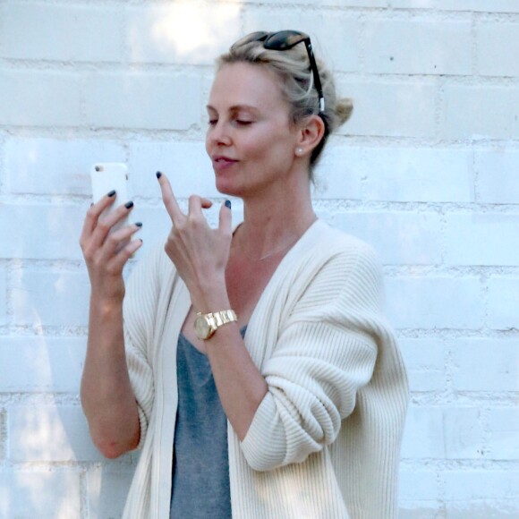 Exclusif - Charlize Theron s'échappe dans la rue quelques instants pour discuter et plaisanter en FaceTime avec un mystérieux inconnu à Hollywood. Elle s'amuse à faire un doigt d'honneur et envoi un baiser à son interlocuteur avant de raccrocher. Le 5 juillet 2016