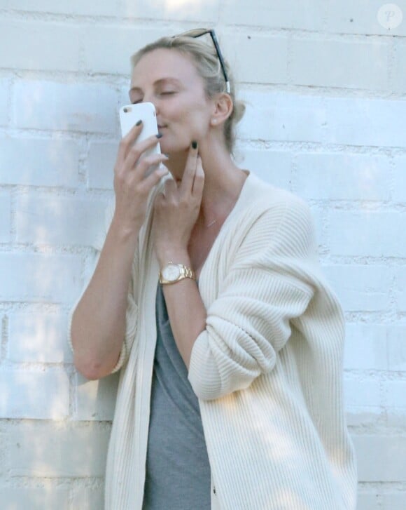Exclusif - Charlize Theron s'échappe dans la rue quelques instants pour discuter et plaisanter en FaceTime avec un mystérieux inconnu à Hollywood. Elle s'amuse à faire un doigt d'honneur et envoi un baiser à son interlocuteur avant de raccrocher. Le 5 juillet 2016