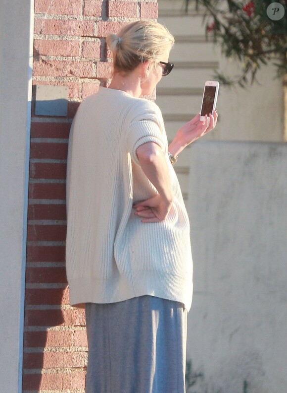 Exclusif - Charlize Theron s'échappe dans la rue quelques instants pour discuter et plaisanter en FaceTime avec un mystérieux inconnu à Hollywood. Elle s'amuse à faire un doigt d'honneur et envoi un baiser à son interlocuteur avant de raccrocher. Le 5 juillet 2016