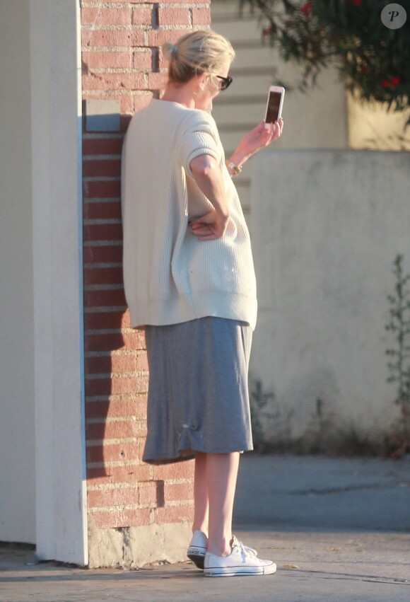 Exclusif - Charlize Theron s'échappe dans la rue quelques instants pour discuter et plaisanter en FaceTime avec un mystérieux inconnu à Hollywood. Elle s'amuse à faire un doigt d'honneur et envoi un baiser à son interlocuteur avant de raccrocher. Le 5 juillet 2016
