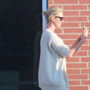 Exclusif - Charlize Theron s'échappe dans la rue quelques instants pour discuter et plaisanter en FaceTime avec un mystérieux inconnu à Hollywood. Elle s'amuse à faire un doigt d'honneur et envoi un baiser à son interlocuteur avant de raccrocher. Le 5 juillet 2016