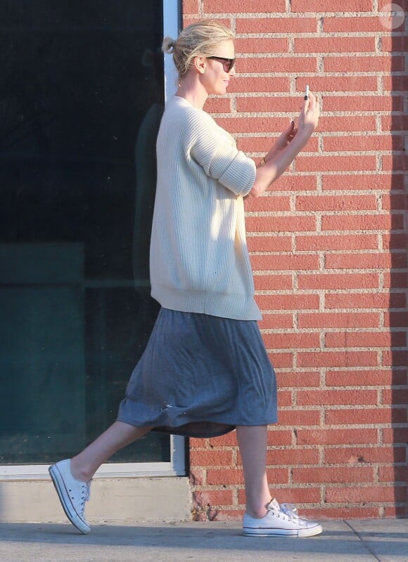 Exclusif - Charlize Theron s'échappe dans la rue quelques instants pour discuter et plaisanter en FaceTime avec un mystérieux inconnu à Hollywood. Elle s'amuse à faire un doigt d'honneur et envoi un baiser à son interlocuteur avant de raccrocher. Le 5 juillet 2016