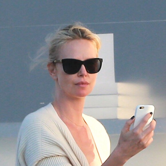 Exclusif - Charlize Theron s'échappe dans la rue quelques instants pour discuter et plaisanter en FaceTime avec un mystérieux inconnu à Hollywood. Elle s'amuse à faire un doigt d'honneur et envoi un baiser à son interlocuteur avant de raccrocher. Le 5 juillet 2016