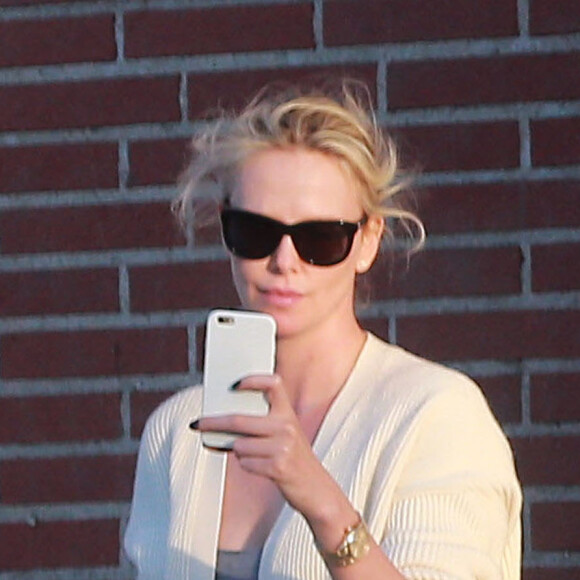 Exclusif - Charlize Theron s'échappe dans la rue quelques instants pour discuter et plaisanter en FaceTime avec un mystérieux inconnu à Hollywood. Elle s'amuse à faire un doigt d'honneur et envoi un baiser à son interlocuteur avant de raccrocher. Le 5 juillet 2016