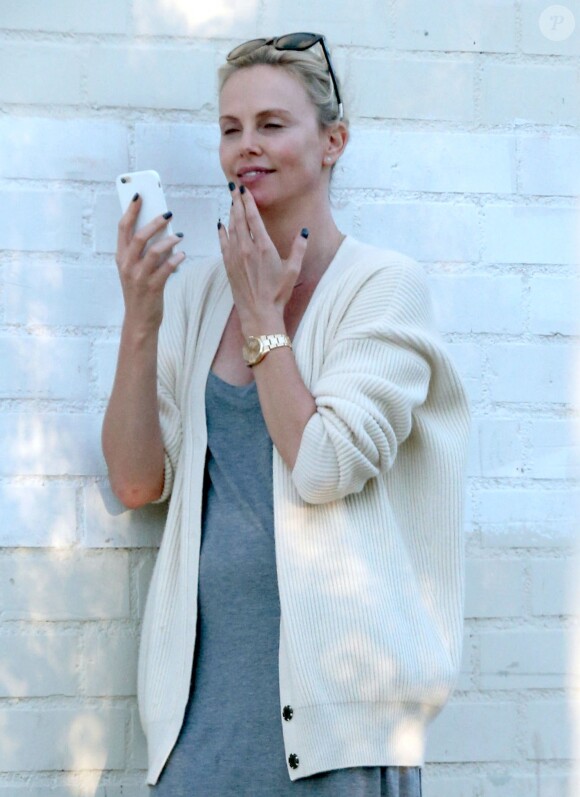 Exclusif - Charlize Theron s'échappe dans la rue quelques instants pour discuter et plaisanter en FaceTime avec un mystérieux inconnu à Hollywood. Elle s'amuse à faire un doigt d'honneur et envoi un baiser à son interlocuteur avant de raccrocher. Le 5 juillet 2016