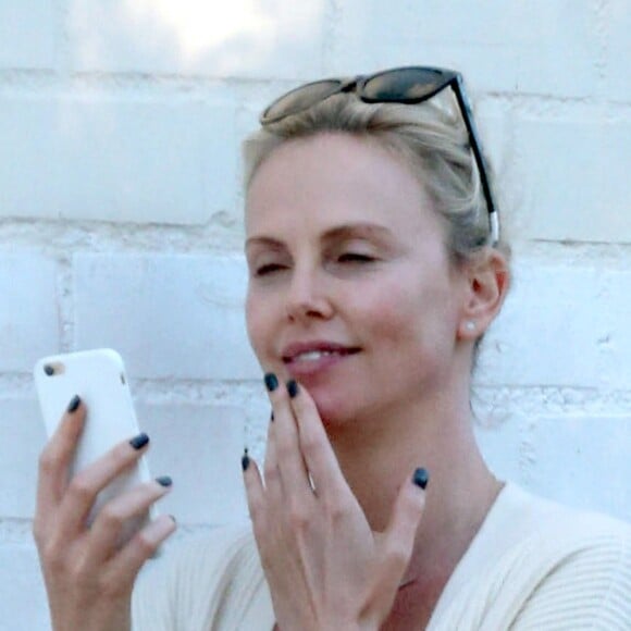 Exclusif - Charlize Theron s'échappe dans la rue quelques instants pour discuter et plaisanter en FaceTime avec un mystérieux inconnu à Hollywood. Elle s'amuse à faire un doigt d'honneur et envoi un baiser à son interlocuteur avant de raccrocher. Le 5 juillet 2016