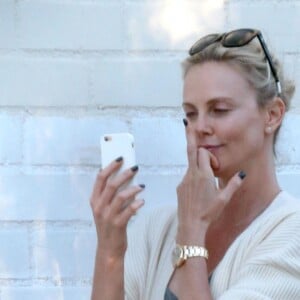 Exclusif - Charlize Theron s'échappe dans la rue quelques instants pour discuter et plaisanter en FaceTime avec un mystérieux inconnu à Hollywood. Elle s'amuse à faire un doigt d'honneur et envoi un baiser à son interlocuteur avant de raccrocher. Le 5 juillet 2016