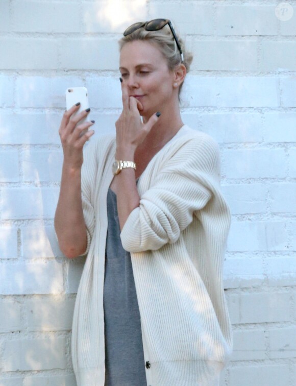 Exclusif - Charlize Theron s'échappe dans la rue quelques instants pour discuter et plaisanter en FaceTime avec un mystérieux inconnu à Hollywood. Elle s'amuse à faire un doigt d'honneur et envoi un baiser à son interlocuteur avant de raccrocher. Le 5 juillet 2016
