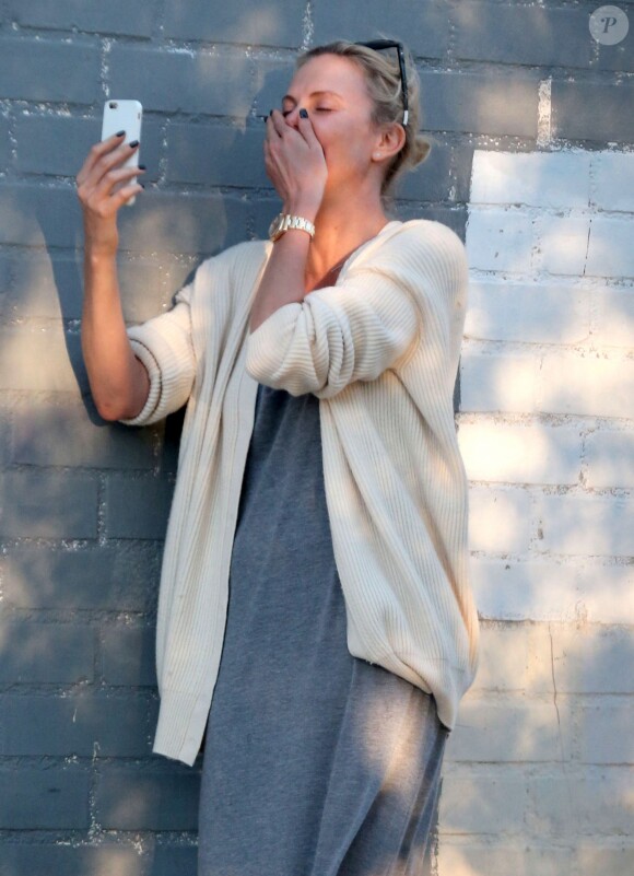 Exclusif - Charlize Theron s'échappe dans la rue quelques instants pour discuter et plaisanter en FaceTime avec un mystérieux inconnu à Hollywood. Elle s'amuse à faire un doigt d'honneur et envoi un baiser à son interlocuteur avant de raccrocher. Le 5 juillet 2016