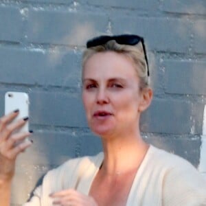 Exclusif - Charlize Theron s'échappe dans la rue quelques instants pour discuter et plaisanter en FaceTime avec un mystérieux inconnu à Hollywood. Elle s'amuse à faire un doigt d'honneur et envoi un baiser à son interlocuteur avant de raccrocher. Le 5 juillet 2016