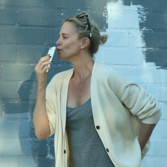 Exclusif - Charlize Theron s'échappe dans la rue quelques instants pour discuter et plaisanter en FaceTime avec un mystérieux inconnu à Hollywood. Elle s'amuse à faire un doigt d'honneur et envoi un baiser à son interlocuteur avant de raccrocher. Le 5 juillet 2016