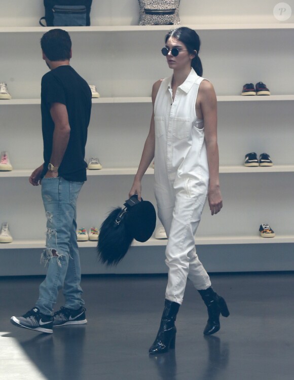 Scott Disick et Kendall Jenner, habillée d'une combi One Teaspoon (modèle Braxton Suit), d'un sac Givenchy (modèle Nightingale) et de bottines vernies Kenneth Cole, font du shopping au magasin Saint Laurent Paris à Beverly Hills. Le 2 juillet 2016.