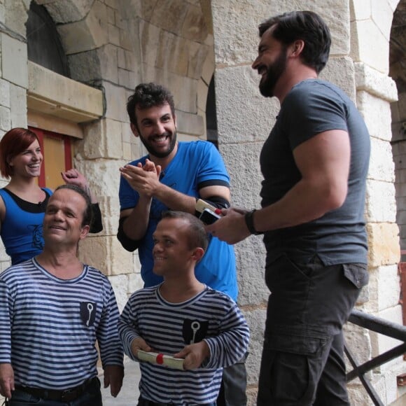 Laurent Ournac tout sourire face à EnjoyPhoenix et Yann-Alrick Morteuil remplis de boue, dans "Fort Boyard" diffusé le 16 juillet 2016, sur France 2