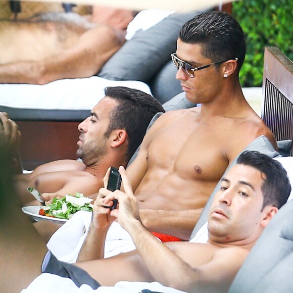 Exclusif - Le joueur de football Cristiano Ronaldo se relaxe autour de la piscine avec des amis à Miami, Floride, Etats-Unis, le 31 Juillet 2016. Il est un peu angoissé, il se mange les ongles avant de manger une salade.  Exclusive - For Germany Call For Price - Soccer star Cristiano Ronaldo takes a chill day to lay out by the pool in Miami, Florida, USA on July 31, 2016. He anxiously chewed on his finger nails before eating a full salad. His friends appeared to be chatting with him while they tired looking star relaxed.31/07/2016 - Miami