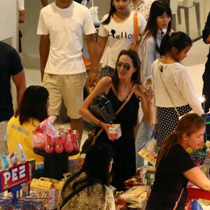 Exclusif - Angelina Jolie, son frère James Haven, et ses enfants Pax (en béquilles à cause de sa jambe cassée suite à son accident de jet-ski) et Maddox Jolie-Pitt font du shopping dans un centre commercial à Phuket. A la sortie du centre commercial, se trouve la porte d'un temple hindou devant laquelle Angelina s'est arrêtée pour prier et se recueillir avec sa famille, le 27 décembre 2015.