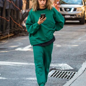 Cara Delevingne, vêtue d'un jogging vert, se balade dans la rue après avoir rendu visite à son amie Taylor Swift à New York, le 10 octobre 2016