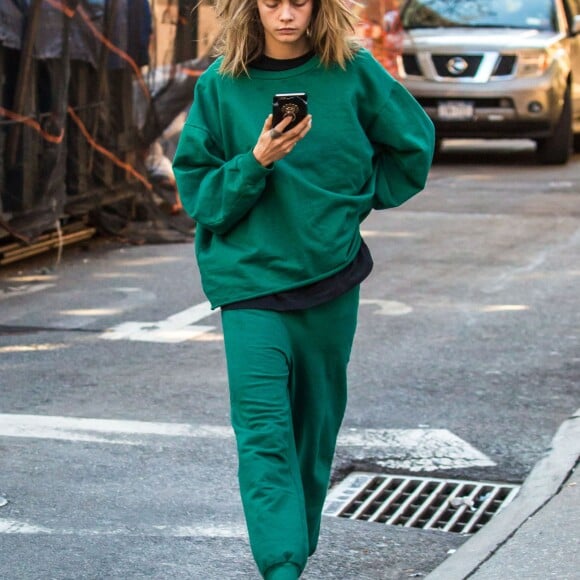 Cara Delevingne, vêtue d'un jogging vert, se balade dans la rue après avoir rendu visite à son amie Taylor Swift à New York, le 10 octobre 2016