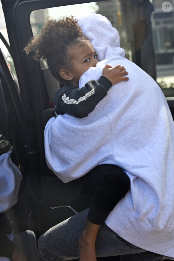 Merci de flouter le visage de l'enfant - Kim Kardashian, cachée par ses vêtements, et sa fille North sortent de son appartement à New York, le 6 octobre 2016. Les photographes ne l'avaient pas vue depuis son retour précipité de Paris après son agression.06/10/2016 - NYC