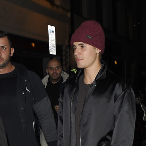 Justin Bieber, escorté par ses gardes du corps, traverse une foule de fans pour se rendre au bar "The Crow" avant d'aller faire la fête à la boîte de nuit "Tape" après la cérémonie des Brit Awards à Londres, le 24 février 2016.