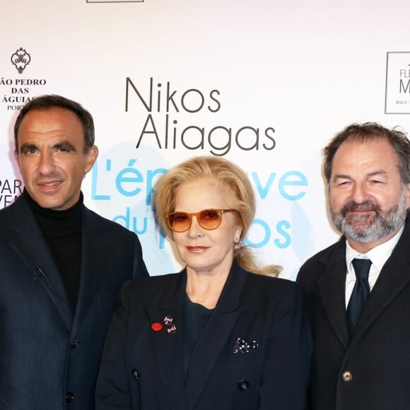 Sylvie Vartan entre Nikos Aliagas et Denis Olivennes - Vernissage de l'exposition "L'épreuve du Temps" de Nikos Aliagas au Palais Brongniart à Paris, le 16 janvier 2017.