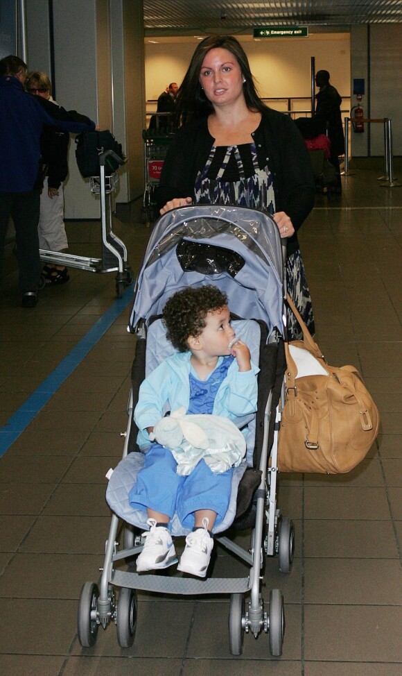 Rebecca Ferdinand, femme de Rio Ferdinand, avec leur fils Lorenz et enceinte de Tate, à l'aéroport de Manchester le 20 mai 2008. Rebecca a succombé à un cancer foudroyant en mai 2015 ; deux ans après, Rio Ferdinand évoquera au printemps 2017 son travail de deuil dans un documentaire de BBC One.