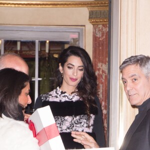 George Clooney et sa femme Amal Alamuddin (enceinte) à la sortie de leur hôtel à Paris se voient offrir un cadeau pour leurs futurs jumeaux par une inconnue. Paris le 25 février 2017