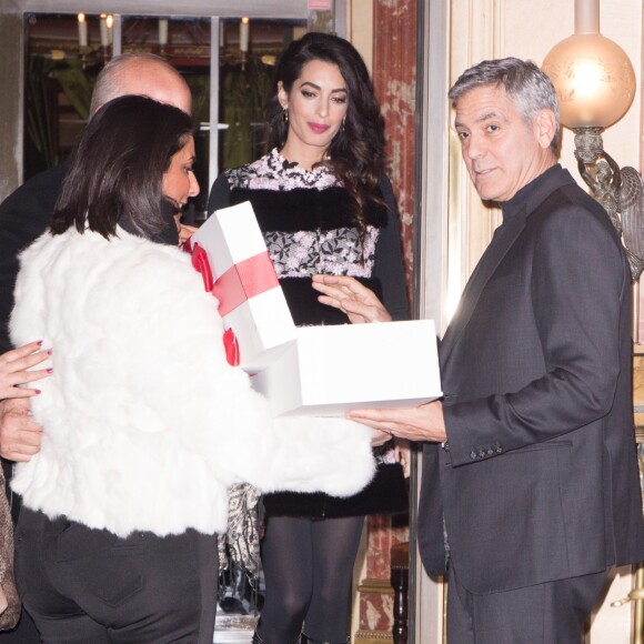George Clooney et sa femme Amal Alamuddin (enceinte) à la sortie de leur hôtel à Paris se voient offrir un cadeau pour leurs futurs jumeaux par une inconnue. Paris le 25 février 2017