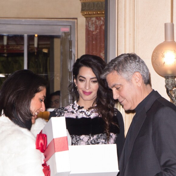 George Clooney et sa femme Amal Alamuddin (enceinte) à la sortie de leur hôtel à Paris se voient offrir un cadeau pour leurs futurs jumeaux par une inconnue. Paris le 25 février 2017