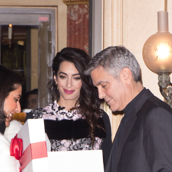 George Clooney et sa femme Amal Alamuddin (enceinte) à la sortie de leur hôtel à Paris se voient offrir un cadeau pour leurs futurs jumeaux par une inconnue. Paris le 25 février 2017