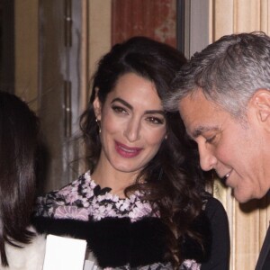 George Clooney et sa femme Amal Alamuddin (enceinte) à la sortie de leur hôtel à Paris se voient offrir un cadeau pour leurs futurs jumeaux par une inconnue. Paris le 25 février 2017