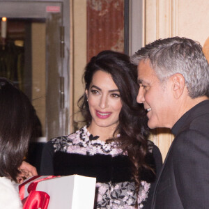 George Clooney et sa femme Amal Alamuddin (enceinte) à la sortie de leur hôtel à Paris se voient offrir un cadeau pour leurs futurs jumeaux par une inconnue. Paris le 25 février 2017