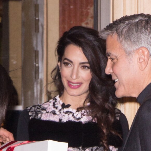 George Clooney et sa femme Amal Alamuddin (enceinte) à la sortie de leur hôtel à Paris se voient offrir un cadeau pour leurs futurs jumeaux par une inconnue. Paris le 25 février 2017