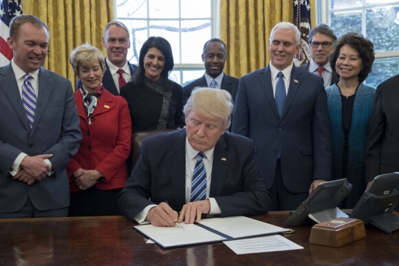 US President Donald J. Trump (C) signs an executive order entitled, 'Comprehensive Plan for Reorganizing the Executive Branch', beside members of his Cabinet in the Oval Office of the White House in Washington, DC, USA, 13 March 2017. Credit: Michael Reynolds / Pool via CNP - NO WIRE SERVICE - Photo: Michael Reynolds/Consolidated News Photos/Michael Reynolds - Pool via CNP13/03/2017 - Washington